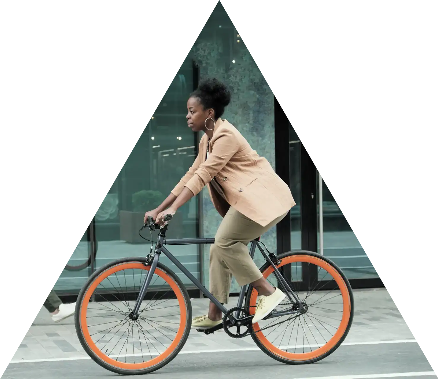 mission-triangle A woman riding a bicycle in an urban setting, in an image cropped into a triangle shape.